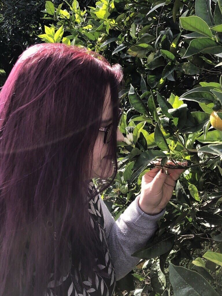 Pia smelling an orange flower